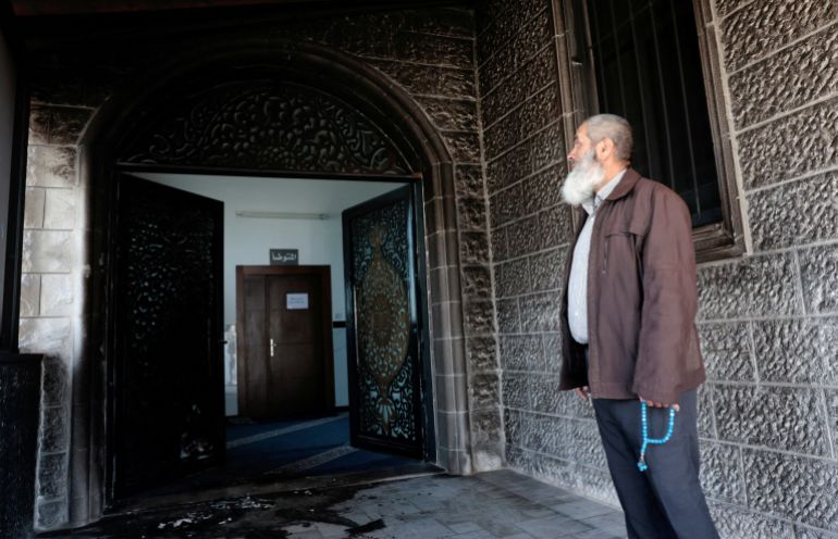 A Palestinian man, holding Misbaha prayer beads, inspects the debris at a mosque, which Palestinians say was damaged by Israeli settlers, in West Bank village of Surra, near Nablus in the Israeli-occupied West Bank, February 23, 2026. REUTERS/Mohamad Torokman TPX IMAGES OF THE DAY