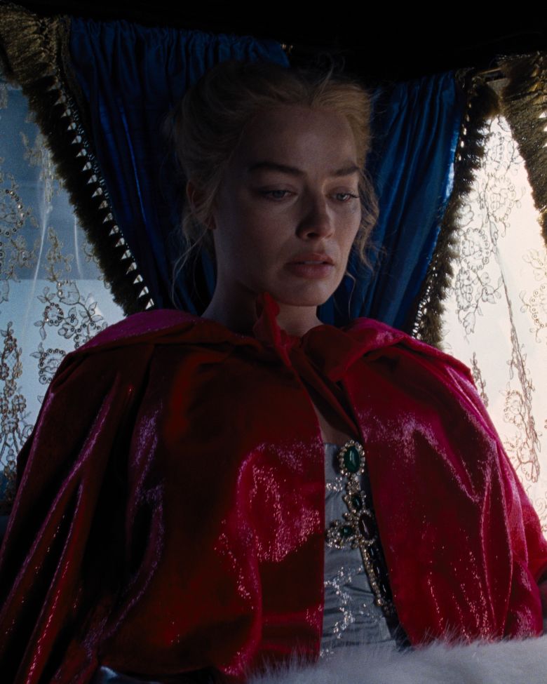 Fennell and Durran put Robbie in an similarly extravagant fur hand-warmer and velvet hooded cape in the new version.