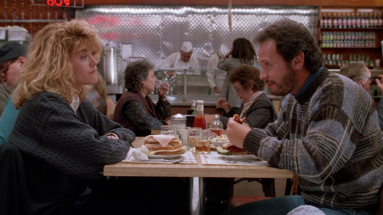 Meg Ryan and Billy Crystal as Sally and Harry sitting across from each other at Katz's in When Harry Met Sally