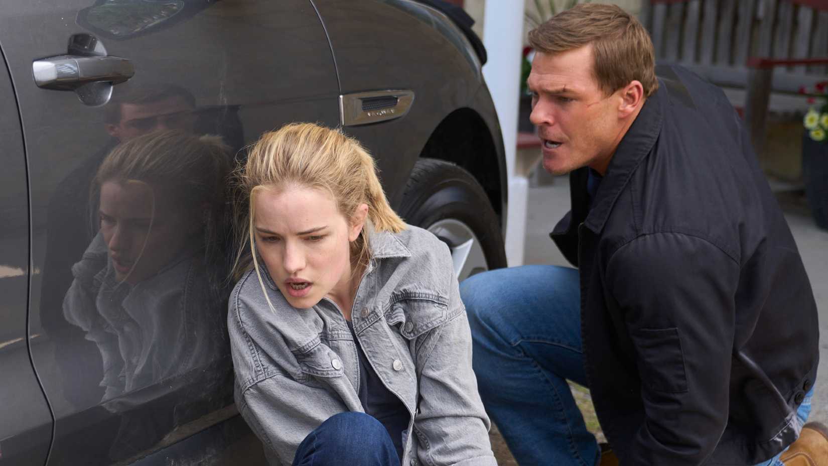 Roscoe and Reacher behind a car