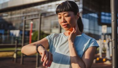 Woman using fitness tracker on wrist, looking at screen after workout