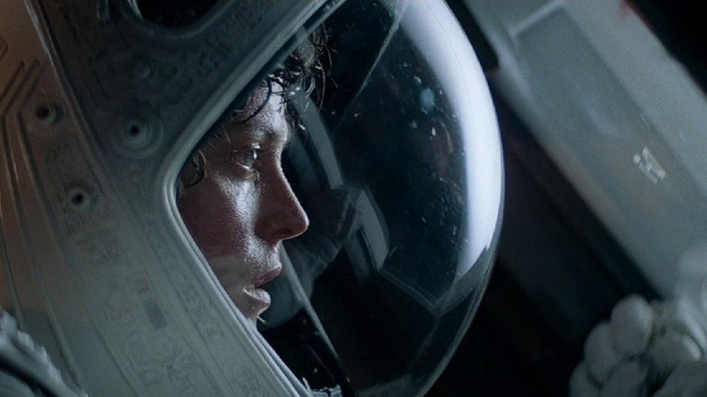 Sigourney Weaver as Ellen Ripley in a space suit looking out a window in Alien