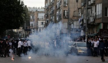 Ultra-Orthodox Jews react to a stun grenade thrown by Israeli police in Bnei Brak. Pic: Reuters