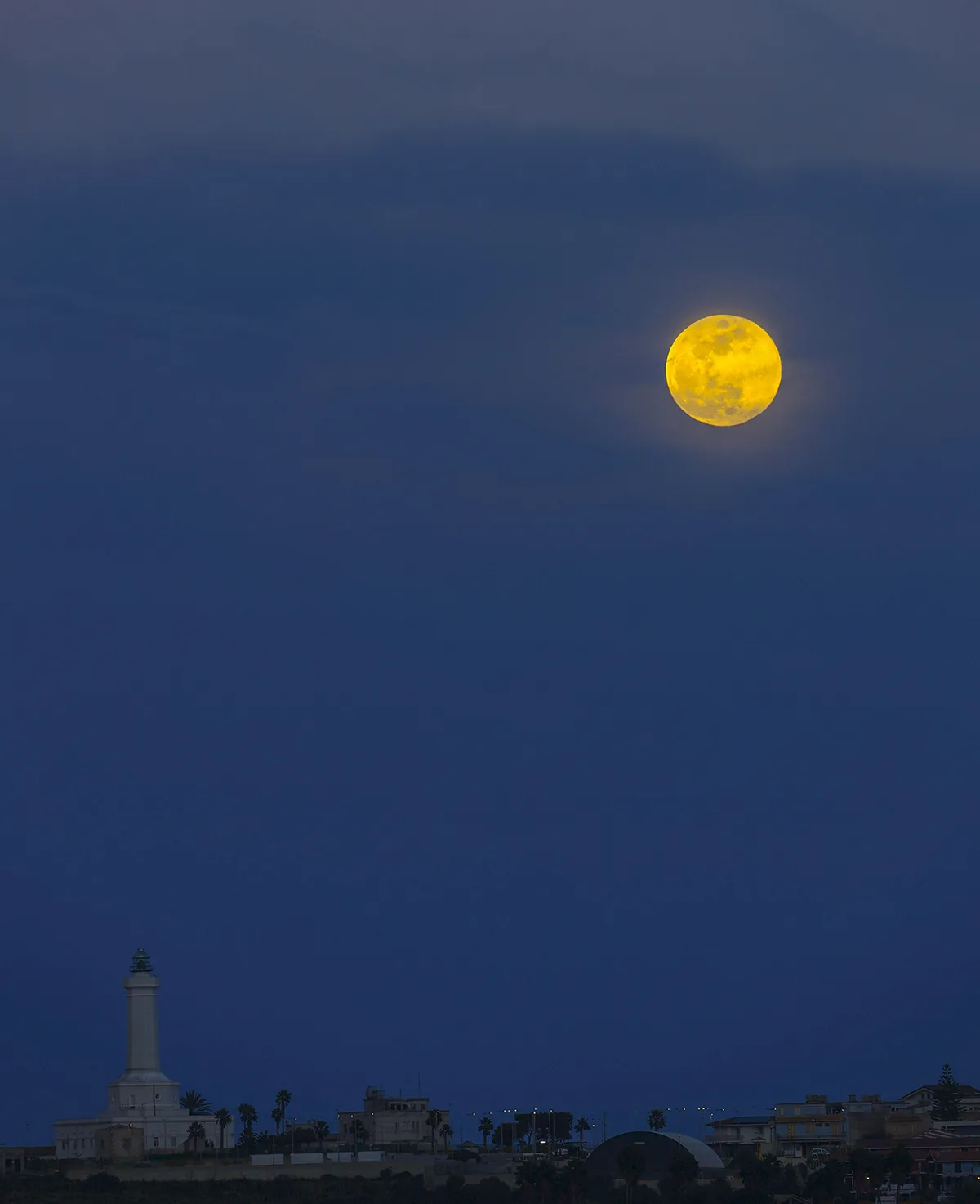The 1 February 2026 Snow Moon above Cozzo Spadaro lighthouse, Portopalo, Sicily, Italy, 17:30 local time, captured by Giovanni Passalacqua. Equipment: Canon EOS R DSLR camera, Sigma 300mm lens. Software: Photoshop