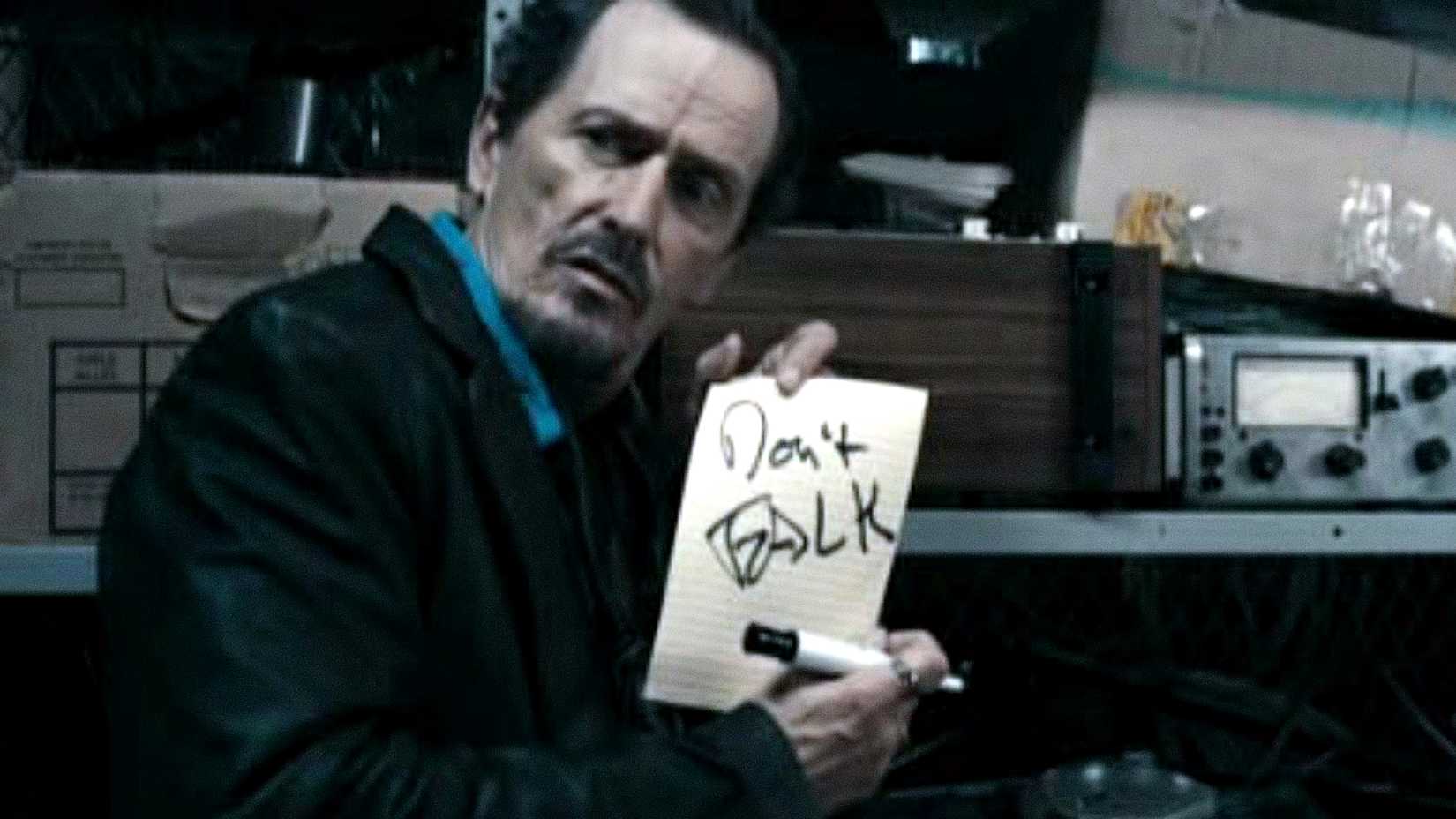 Stephen McHattie's Grant Mazzy holds up a sign that reads Don't Talk in Pontypool