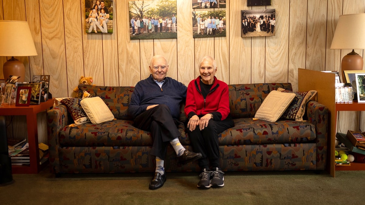 Older couple sit on couch in living room