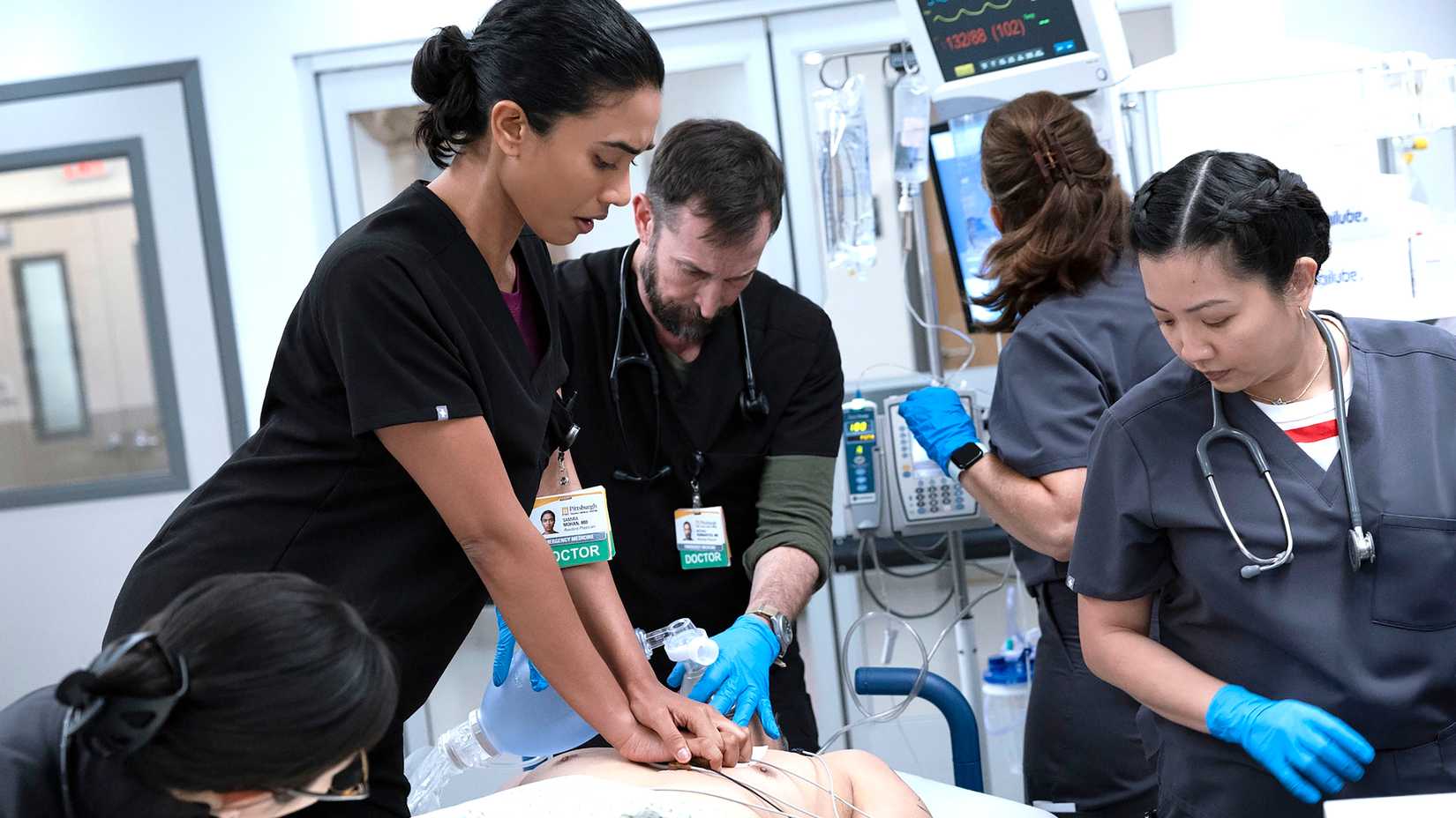Supriya Ganesh's Dr. Samira Mohan performing chest compressions while Noah Wyle's Dr. Robby provides oxygen to a patient in The Pitt season 2