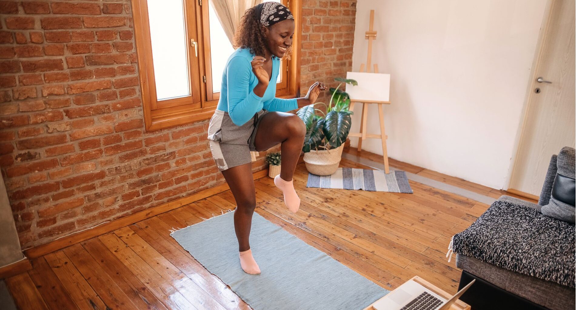 woman does a walking workout at home in front of her laptop