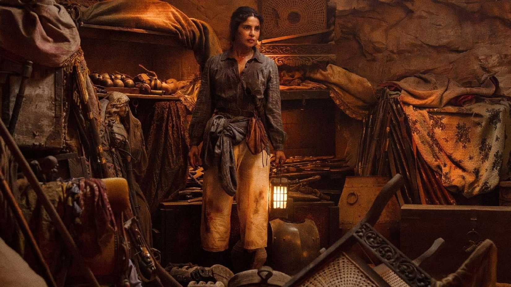 Priyanka Jonas, decked out in her pirate garb, stands amidst an underground cache of weapons in a scene from The Bluff