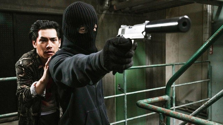 Junichi Okada as Akira, protecting a cowering man in The Fable