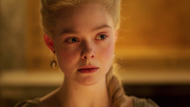 Catherine the Great (Elle Fanning) stands with tears in her eyes in The Great