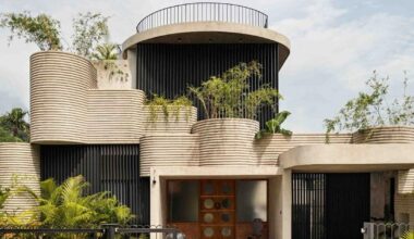 circular green terraces carve through exposed concrete facade in india