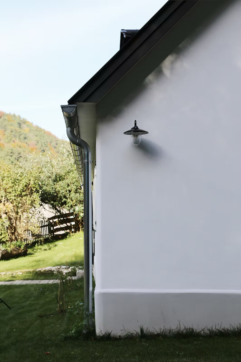 two-centuries old farmhouse and contemporary extension face off in austrian hillscape