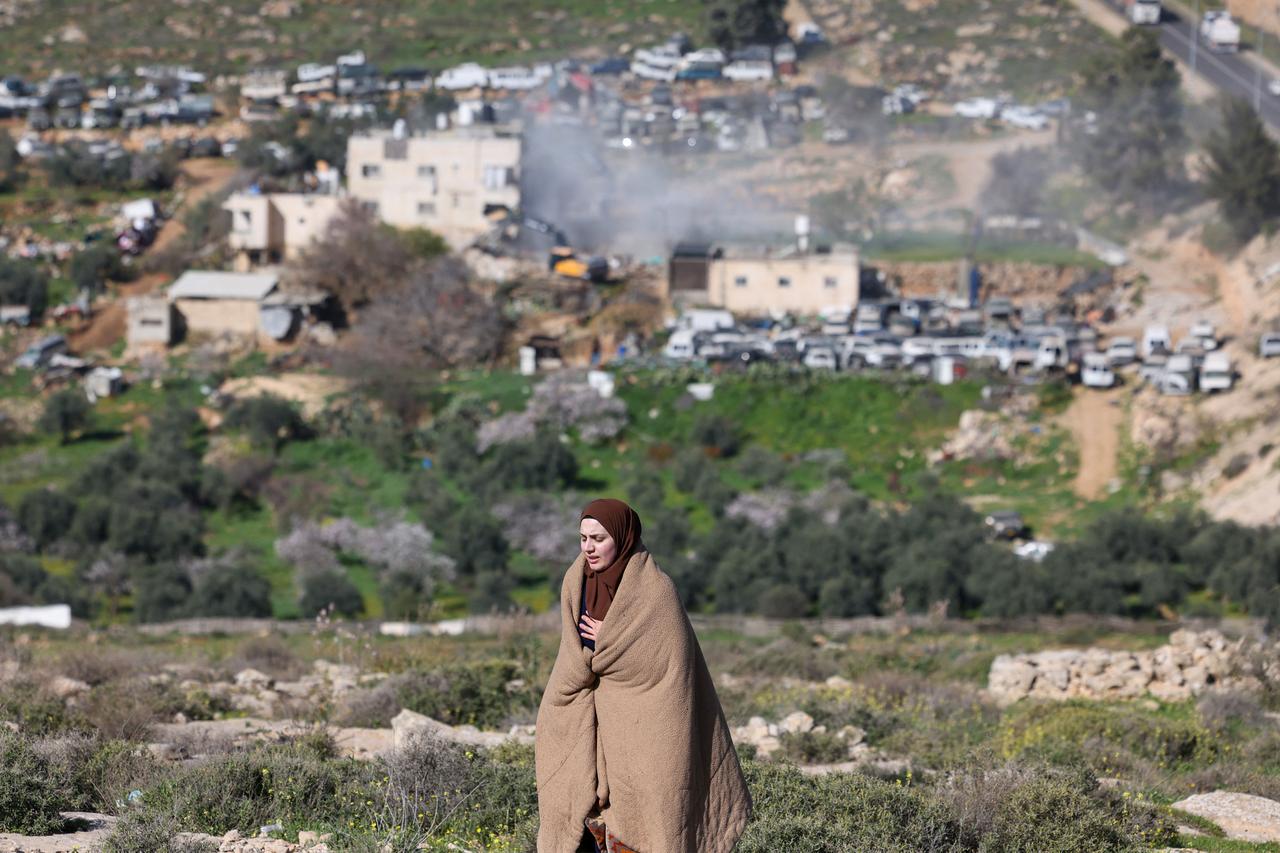 A Palestinian woman reacts as Israeli bulldozers demolish an apartment building belonging to the Salhab family near the Israeli settlement of Hagai, south of the occupied West Bank city of Hebron, on Feb. 18, 2026. (AFP Photo)