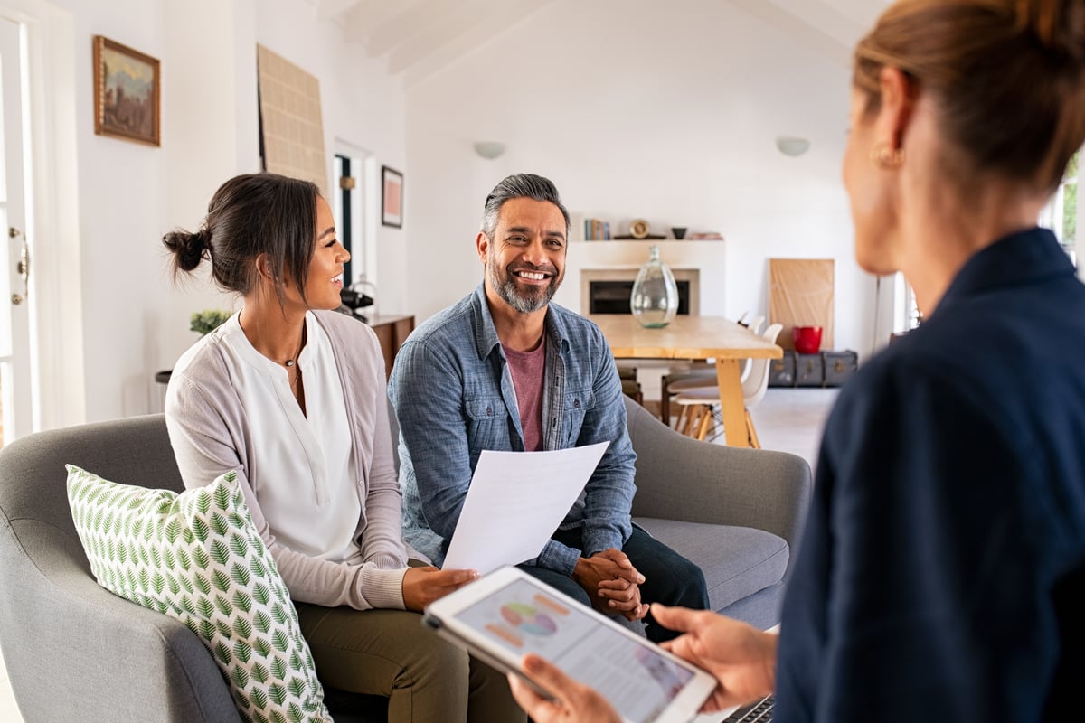 Happy couple discussing with investment advisor.