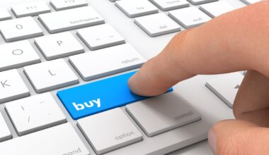 A finger pressing a buy button on a keyboard.