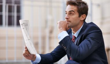 A well-dressed person holding a newspaper looks into the distance with a contemplative expression.
