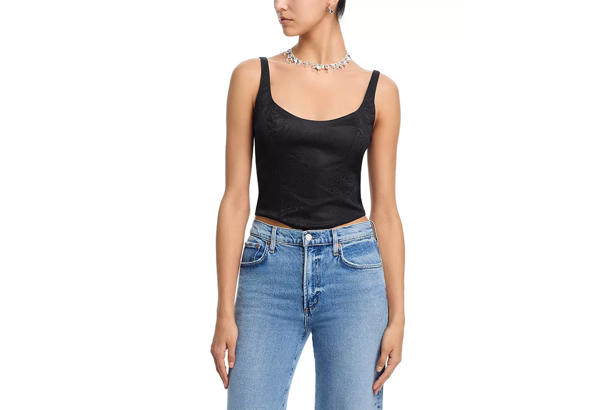 A person wearing a black damask bustier top and light wash blue jeans.