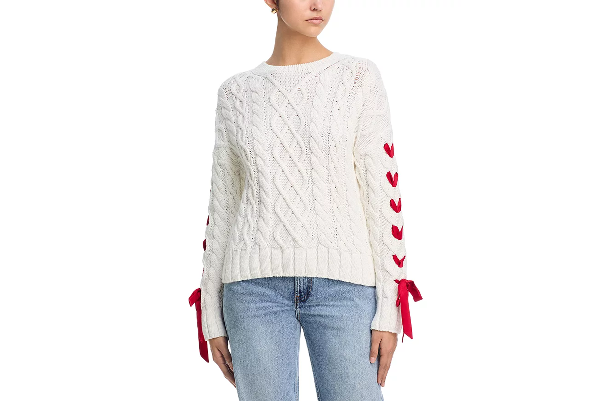 White cable knit sweater with red ribbon lacing up the sleeves and tied in bows at the cuffs.