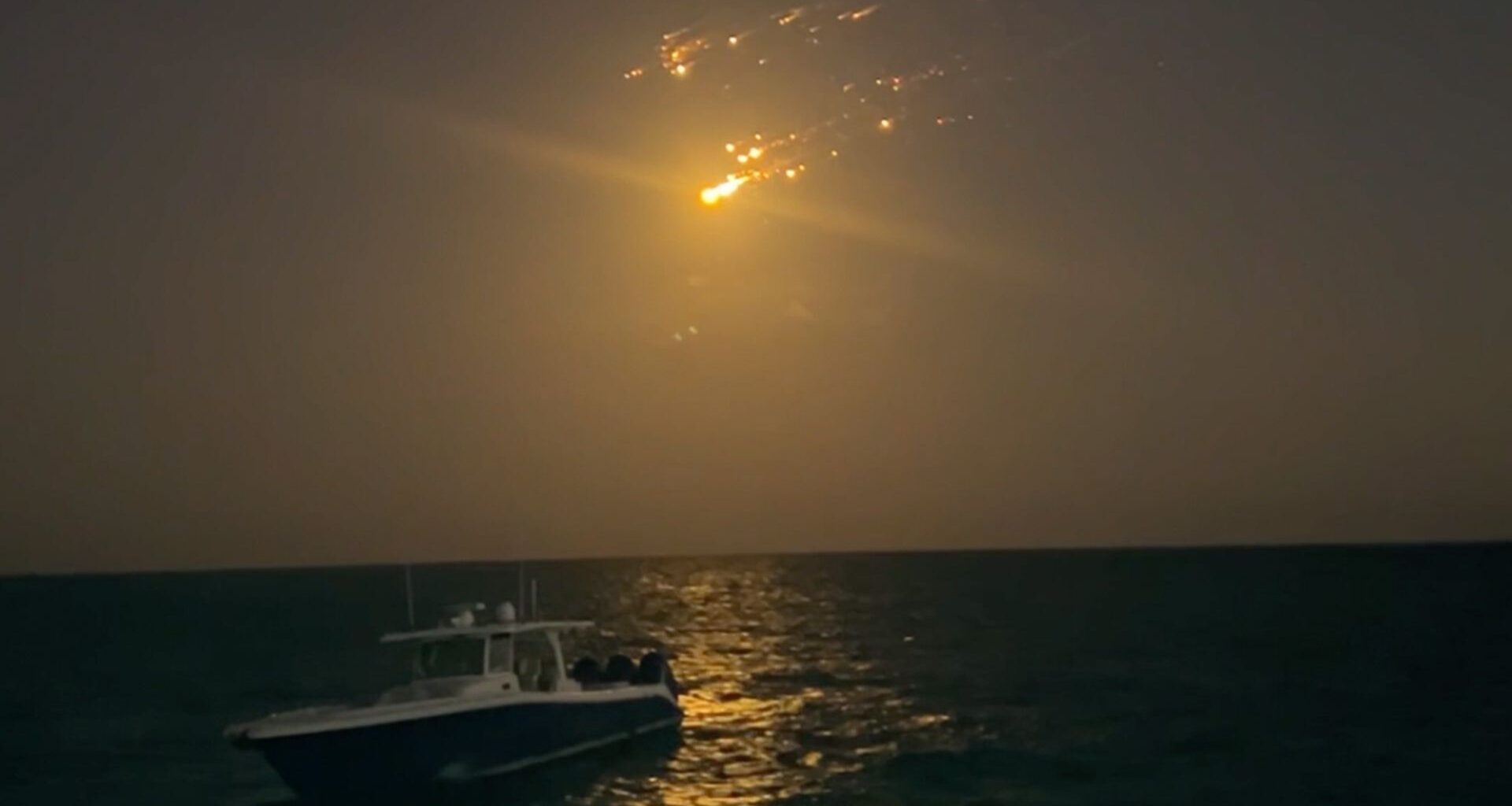 debris from spacex starship falling over a boat in the ocean