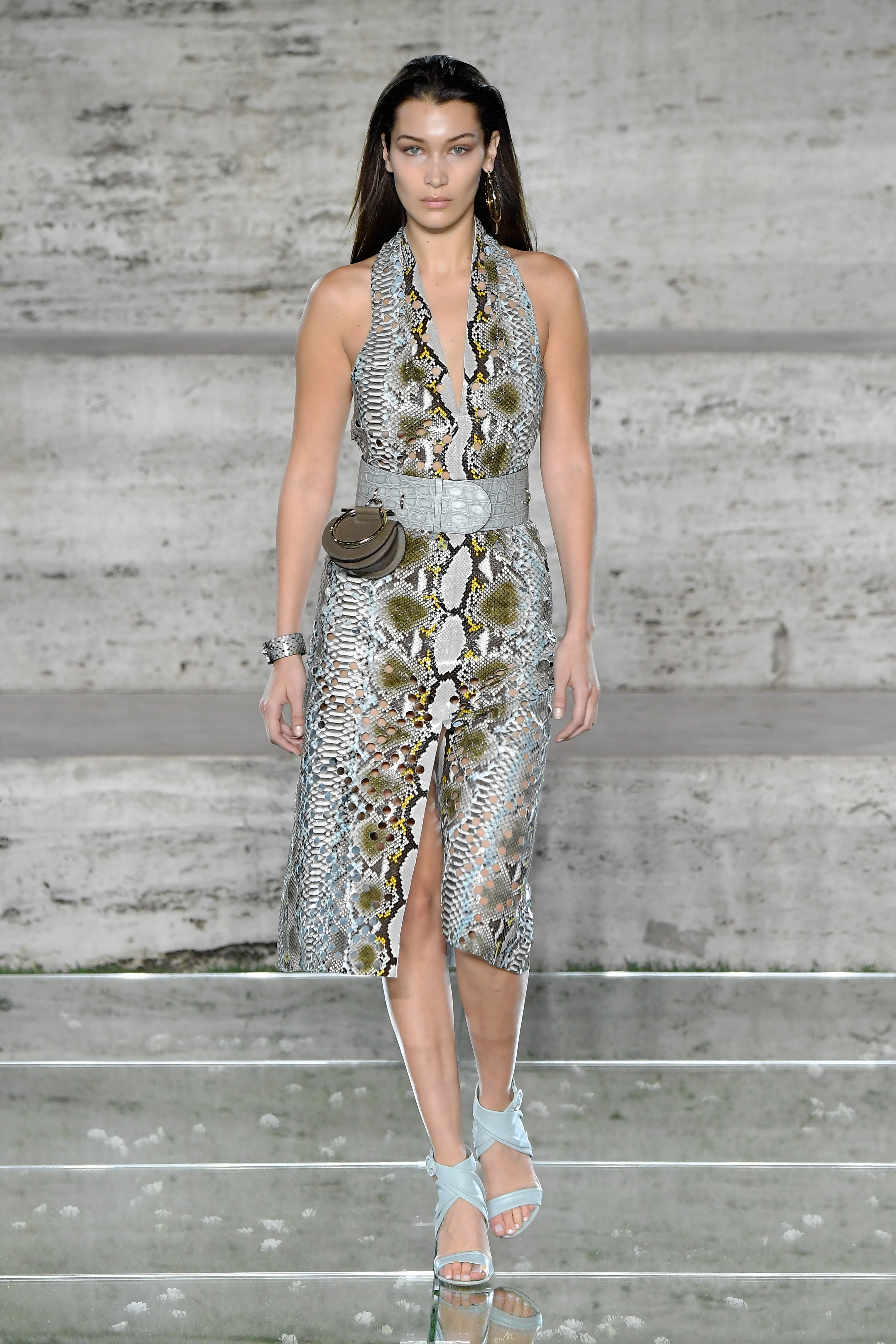 Bella Hadid in a snakeskin print dress with a light blue belt and matching shoes walks the runway for Salvatore Ferragamo.