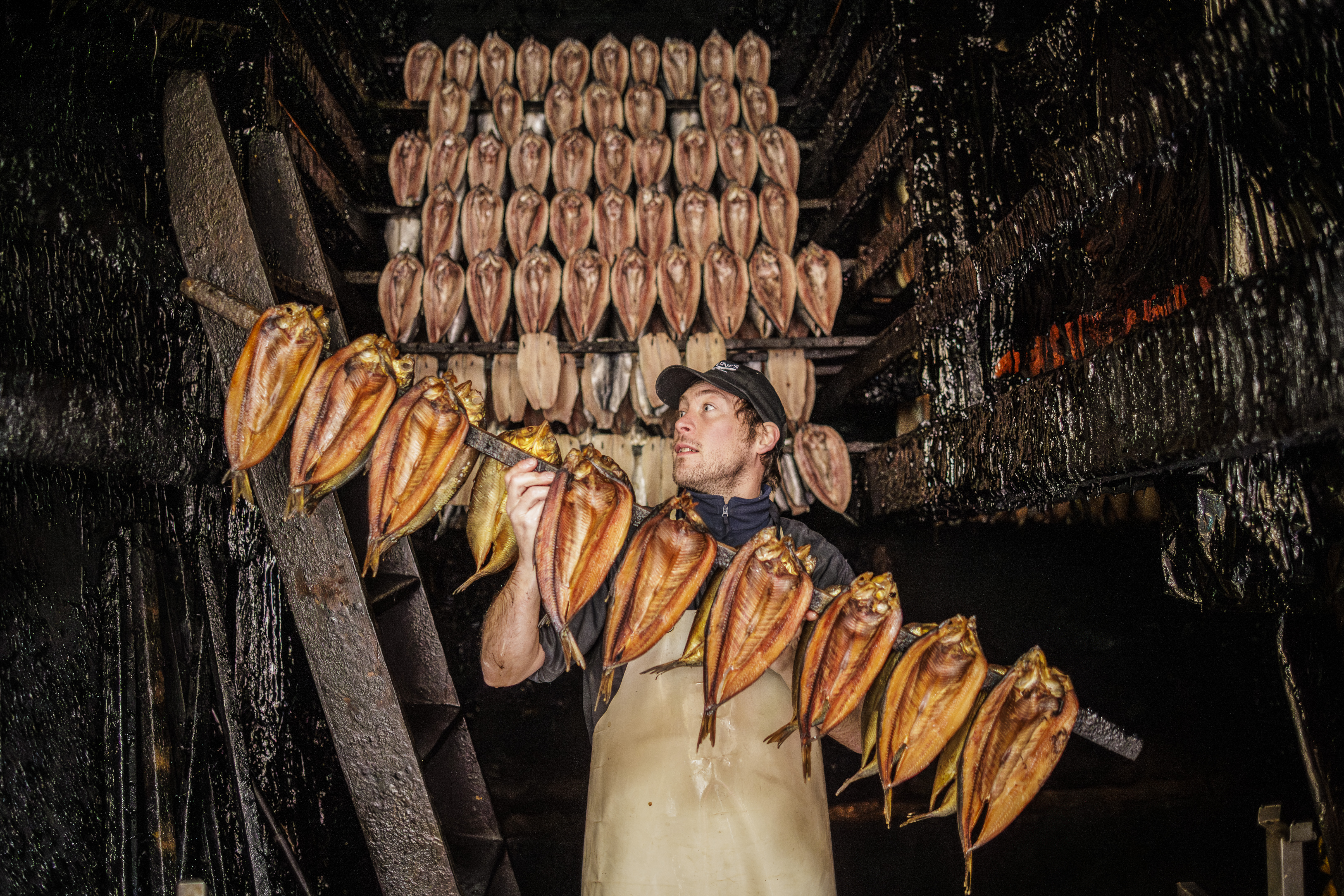 Dan Brown hanging herring on tenterhooks in a traditional smokehouse.