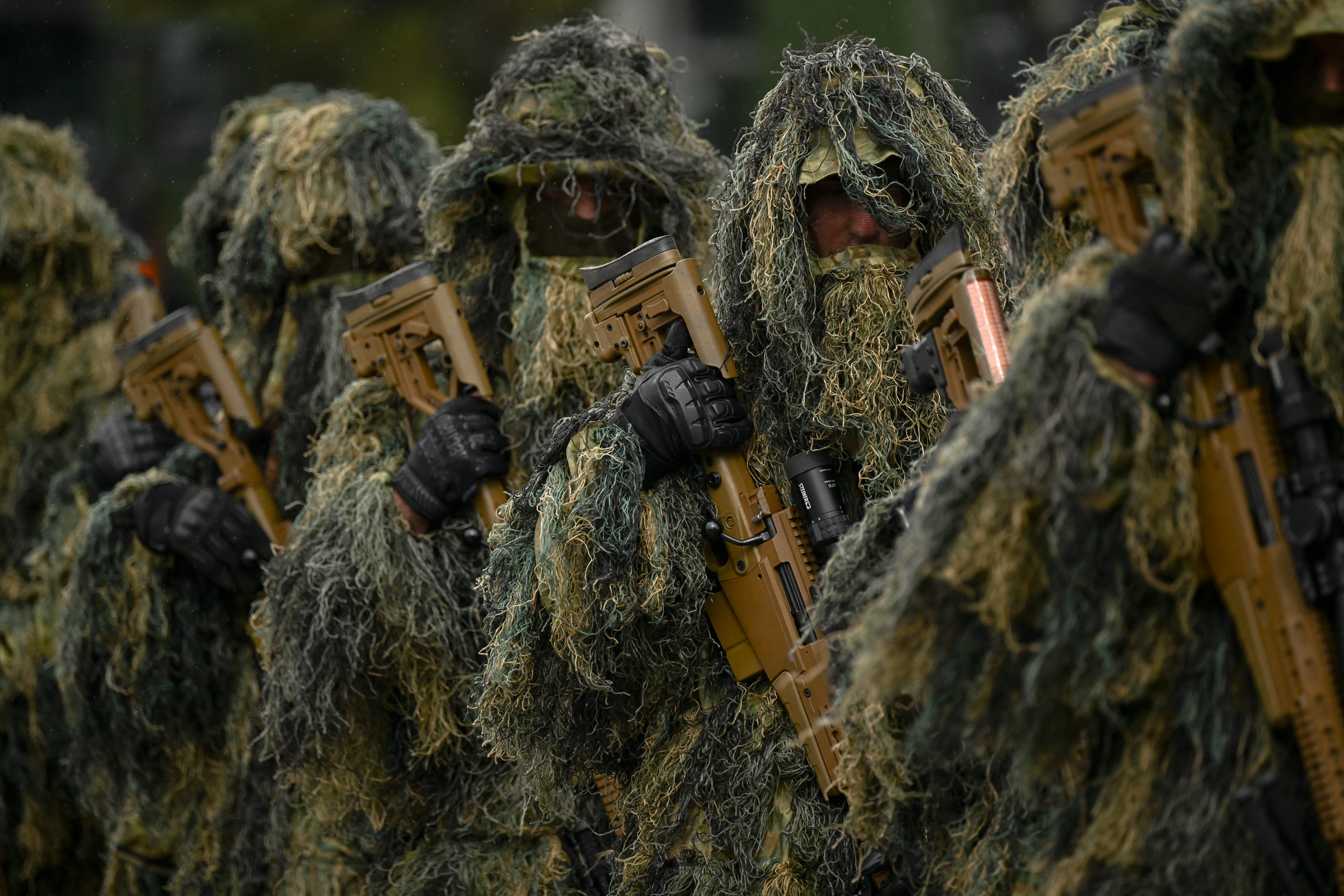 Kosovo Security Force members in ghillie suits holding rifles.