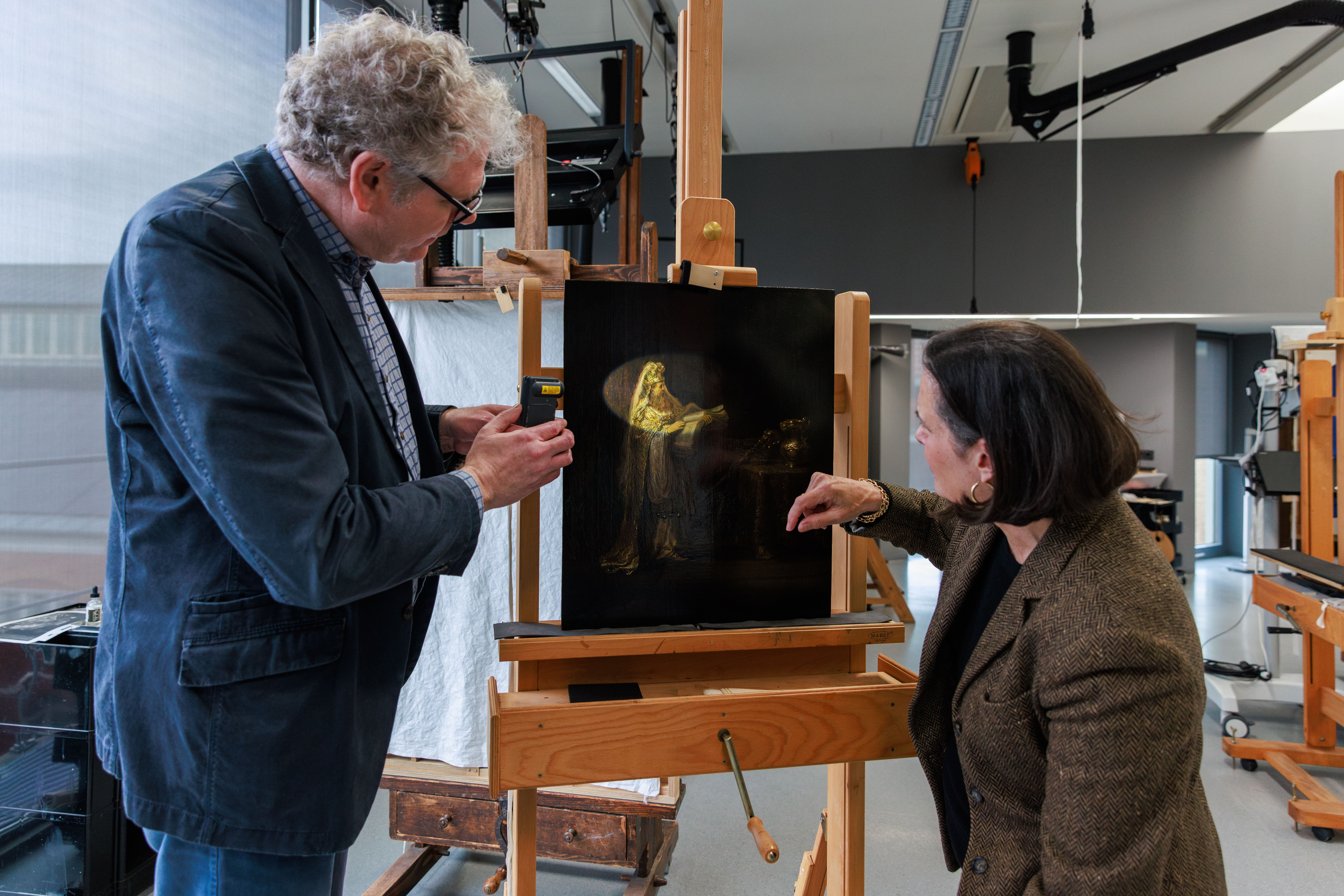 Researchers examining Rembrandt's "Vision of Zacharias in the Temple" from 1633.