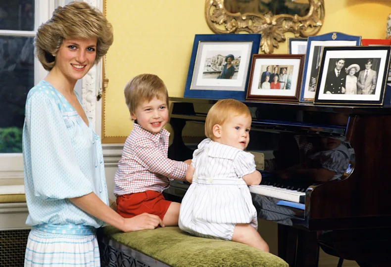 Princess Diana standing at a piano with Harry and William