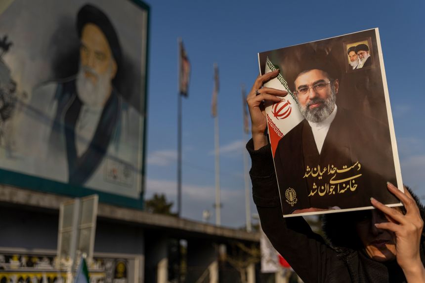 A demonstrator holds a picture of Iran's new Supreme Leader Ayatollah Mojtaba Khamenei during a rally at Enghelab Square in Tehran on March 9.