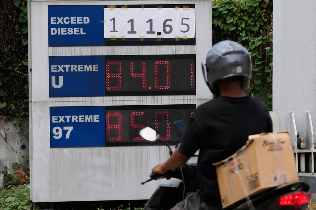 A petrol station in Quezon City, the Philippines, shows diesel prices written on pieces of paper on Thursday as its digital board was not designed to accommodate the number of digits. Photo: AP