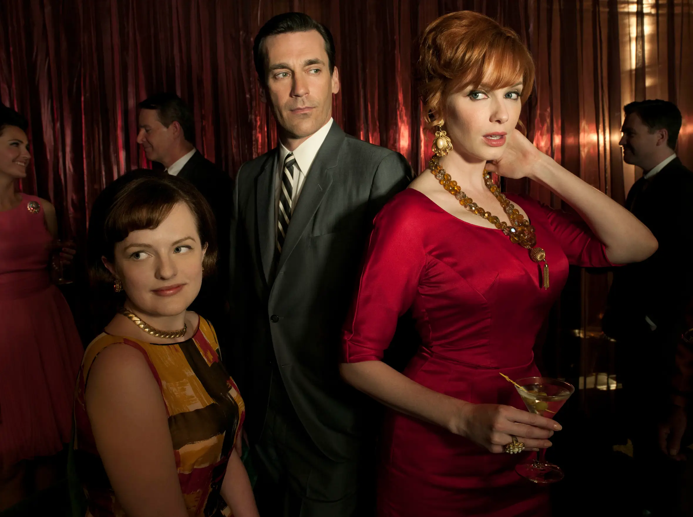 Elisabeth Moss, Jon Hamm, and Christina Hendricks as Peggy Olson, Don Draper, and Joan Harris in Mad Men.