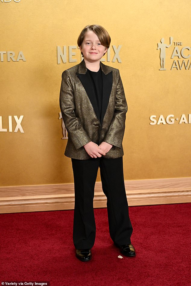 Jacobi, 12, cut a dapper figure in a gold sequinned blazer which he wore with a smart black trousers and top