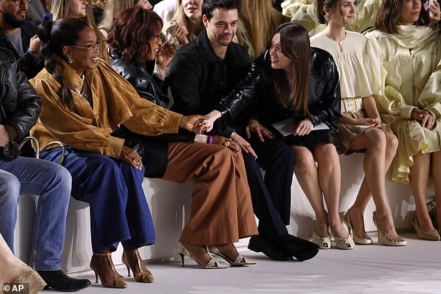 Aimee Lou reached over to hold Oprah's hand as they greeted one another