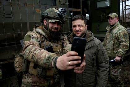 Ukrainian President Volodymyr Zelensky (R) posing for a photo with a Ukrainian serviceman while visiting a main command post in Donetsk region, Friday.