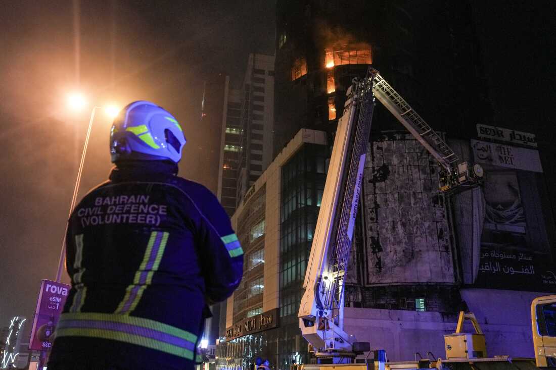 Emergency personnel work to extinguish a fire in a building after an Iranian strike in the capital Manama on February 28, 2026. The United States and Israel launched waves of strikes on February 28 against targets in Iran, sparking swift retaliation by the Islamic republic which responded with missile attacks across the region.