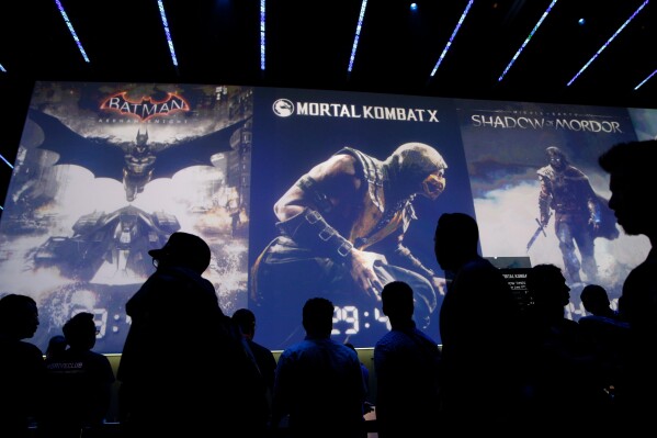 People wait in line for theater presentations for video games including Batman, Mortal Kombat X and Shadow of Mordor at the WB Games booth at the Electronic Entertainment Expo, Wednesday, June 11, 2014, in Los Angeles. (AP Photo/Jae C. Hong, File)