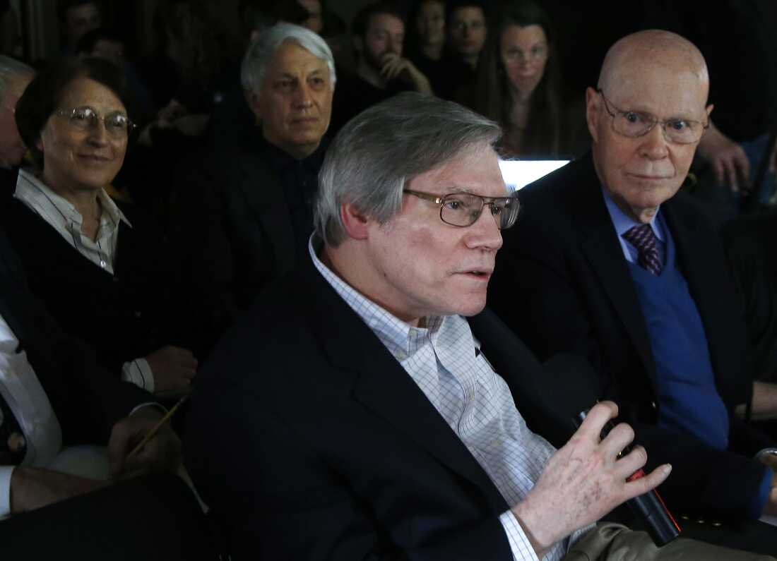 Holding a microphone, Alan Guth asks a question during a news conference at the Harvard-Smithsonian Center for Astrophysics on March 17, 2014. He's seated among rows of people attending the news conference.
