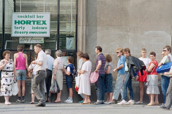 Customers queue outside a bakery in Warsaw, Poland, Aug. 23, 1989. (AP Photo/David Caulkin, File)