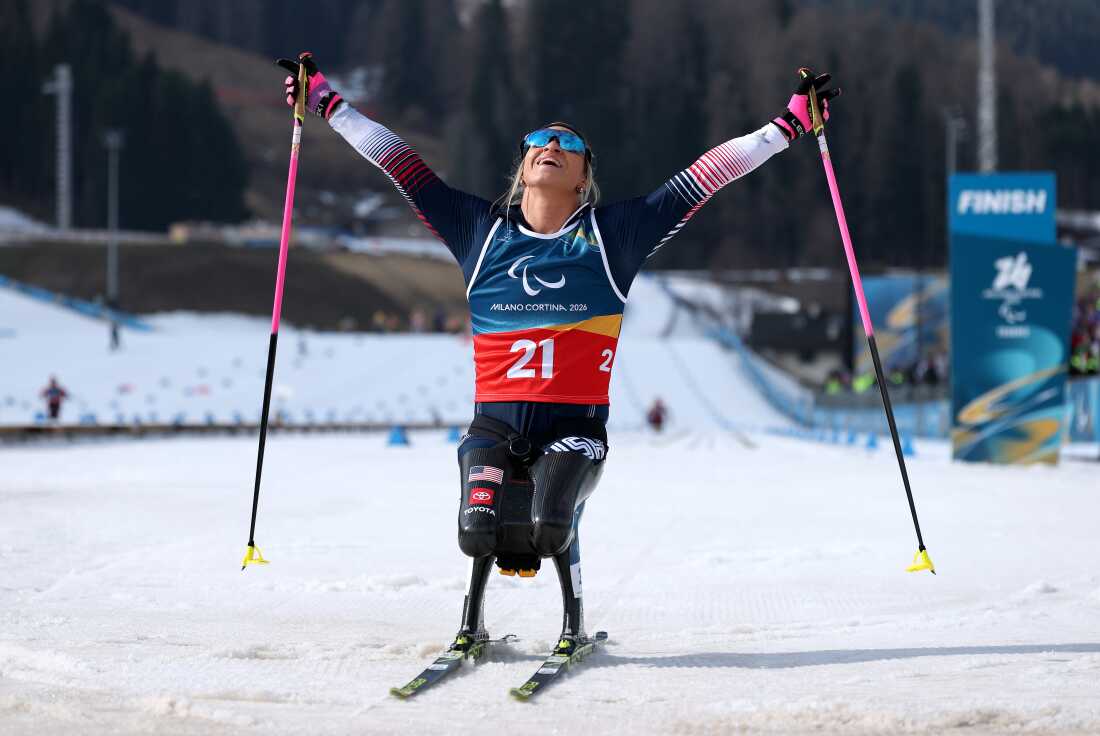 Oksana Masters crosses the finish line in first place during the Women's 10km Para Cross-Country Skiing Sitting race in Italy.
