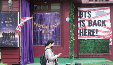A pedestrian walks past JH Texas Bar displaying welcome messages for BTS in Jung District, central Seoul, Sunday, ahead of the boy band’s full-group comeback concert at Gwanghwamun Square this Saturday after three years and nine months. Yonhap