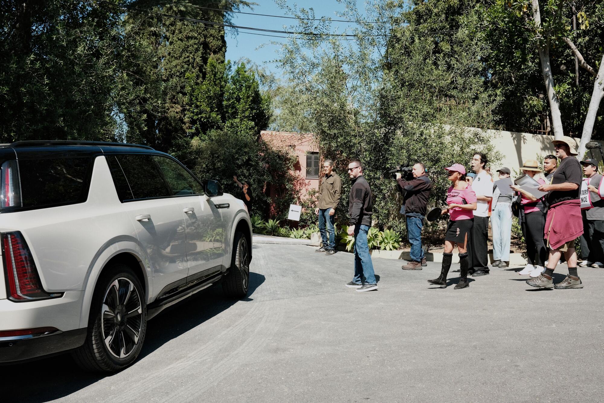 Protesters watch as guests arrive to lunch on Day 1 of the Noma L.A. pop-up.