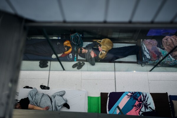 People sleep in an underground metro station used as a shelter against possible Iranian missile attacks in Ramat Gan, Israel, Saturday, March 12, 2026. (AP Photo/Oded Balilty)