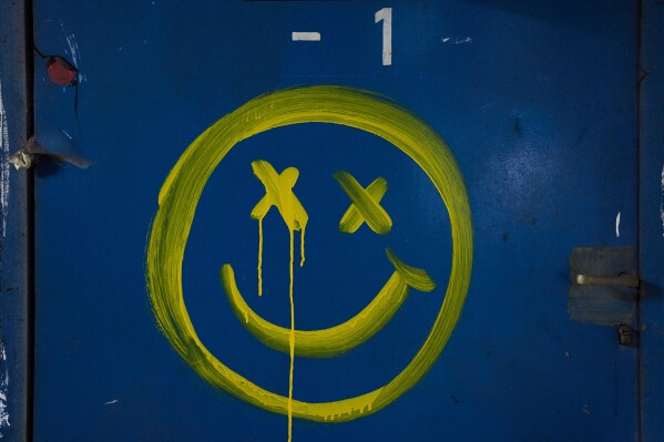 A smiley face is painted on a blue wall beneath Tel Aviv's central bus station, used as a shelter against possible Iranian missile attacks, Thursday, March 12, 2026. (AP Photo/Oded Balilty)