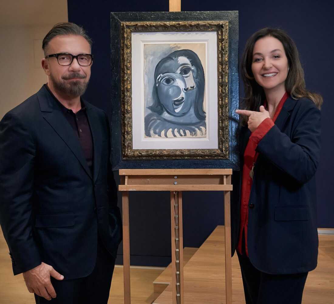 Olivier Widmaier Picasso, left, stands in front of his grandfather Pablo Picasso's 1941 painting Tête de Femme, which is up for grabs as part of a raffle benefiting an Alzheimer's research charity organized by Péri Cochin, right.