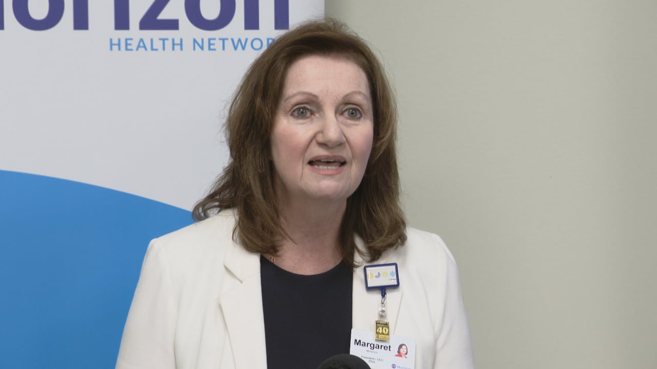 A woman in a doctor's coat speaks