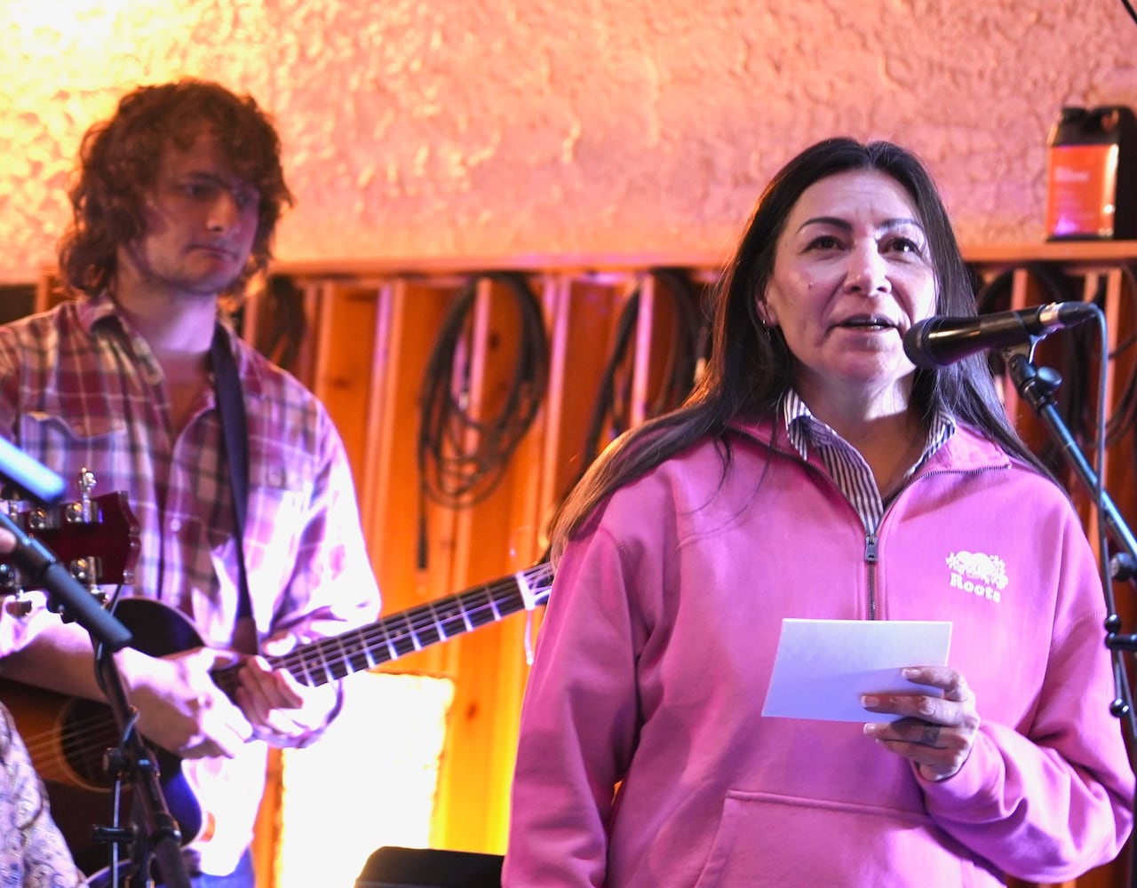 A woman speaks on a stage.