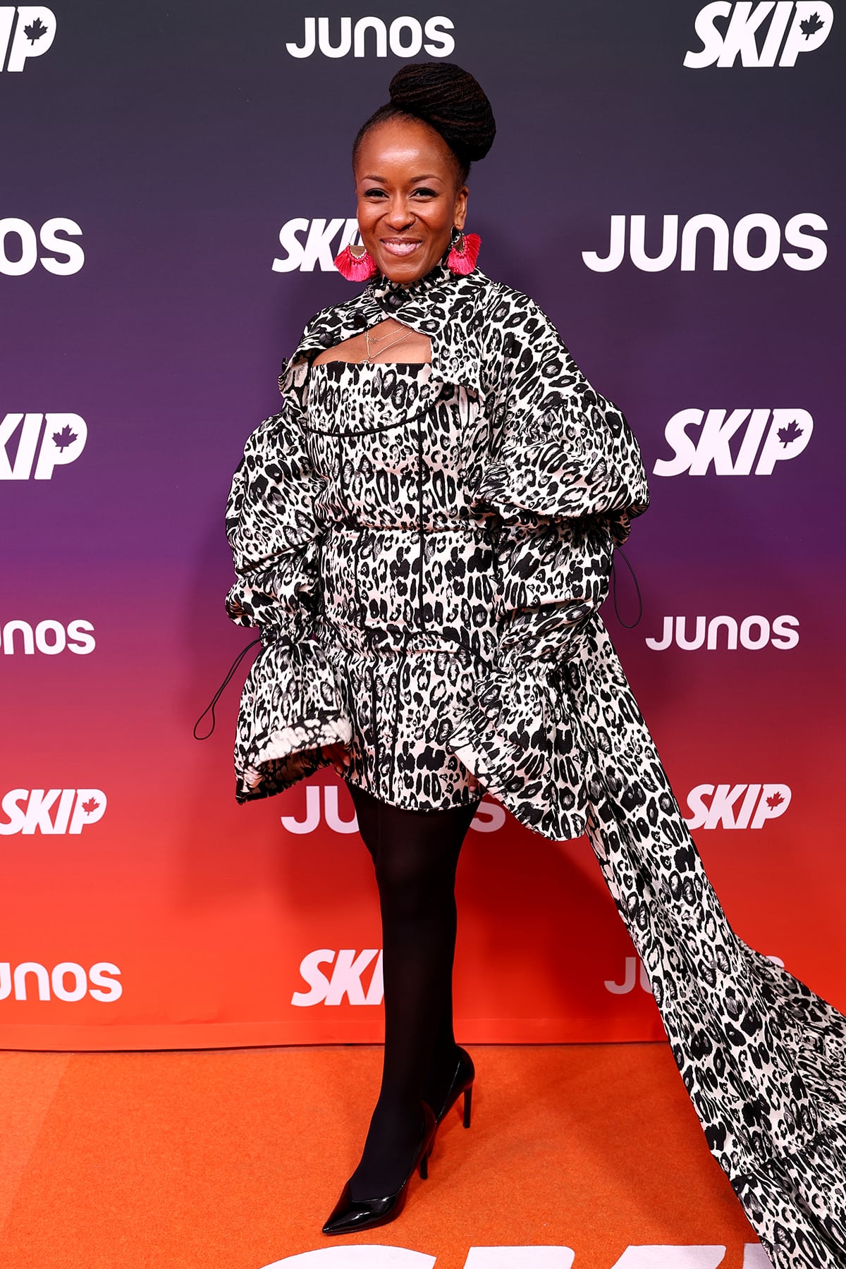 A woman poses for a photo wearing a black-and-white leopard print gown.