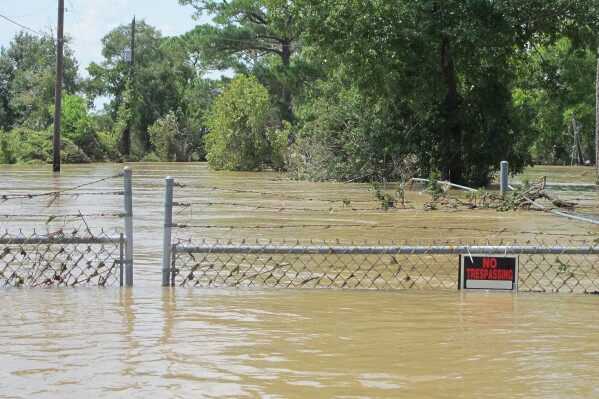 A barbed-wire fence encircles the Highlands Acid Pit that was flooded by water from the nearby San Jacinto River in the aftermath of Hurricane Harvey in Highlands, Texas on Aug. 31, 2017. (AP Photo/Jason Dearen)