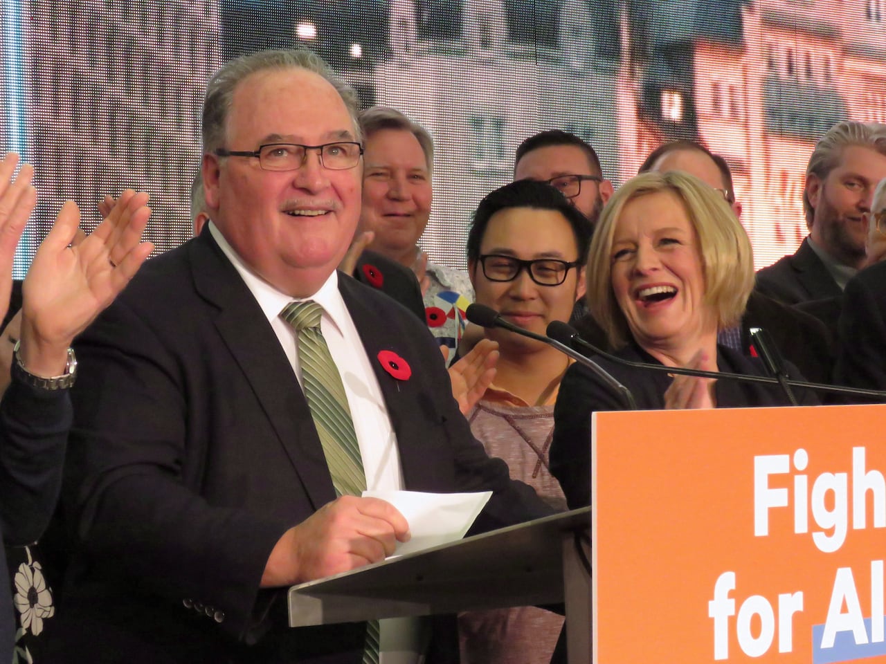 Two people stand behind a podium.